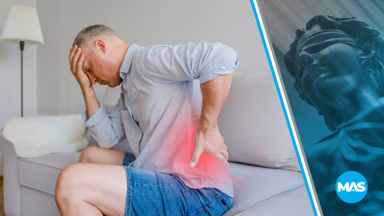 Man on couch suffering from back pain due to an accident.